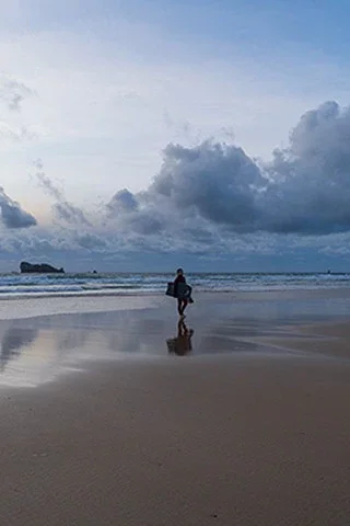 Surfeur au coucher de soleil sur la plage de Pen Hat, à Camaret-sur-Mer