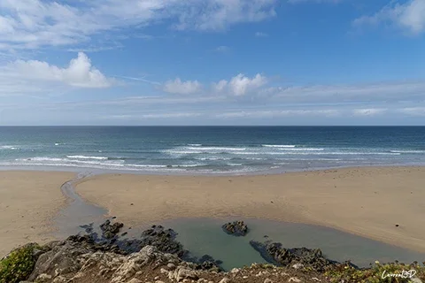 Vue sur les baïnes de la plage de la Palue, sur la presqu’île de Crozon, avec la plage, les rochers et l’océan.
