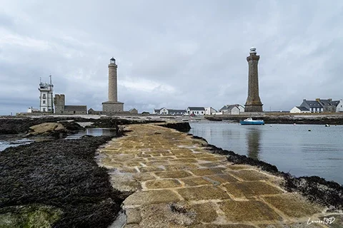Phare d’Eckmühl en Bretagne vu depuis une jetée en pierre sous un ciel couvert